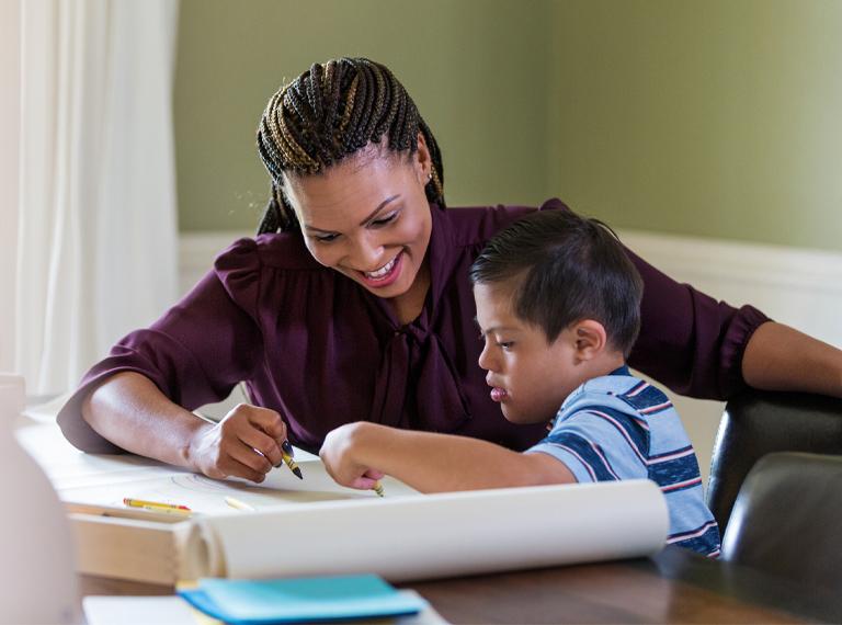 A mid adult woman spends one-on-one time with child with Down Syndrome.