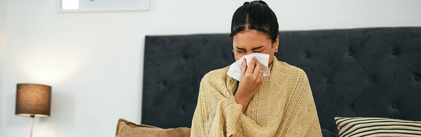 Employee blowing nose and sick in bed