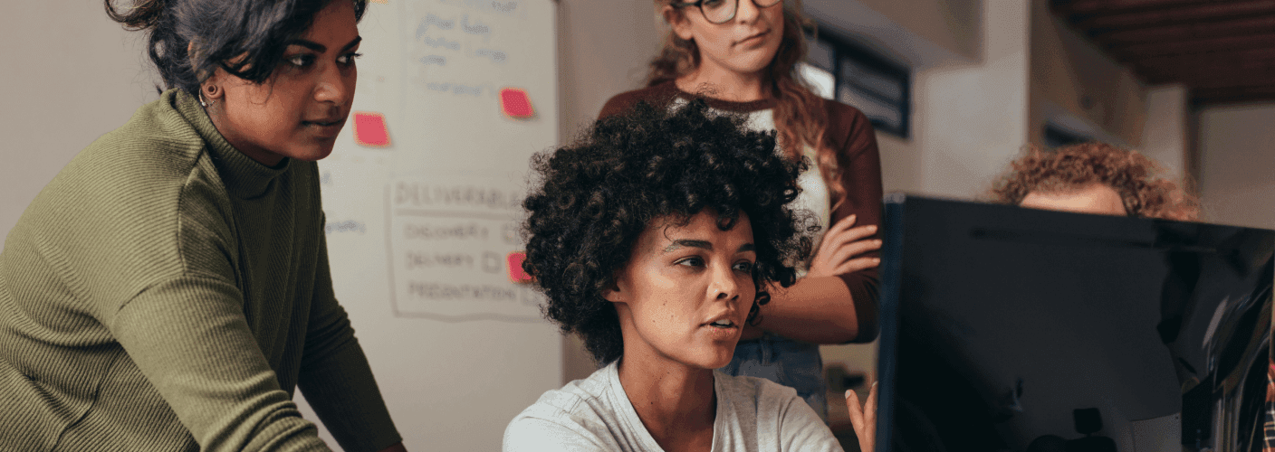 A group of people sitting around a computer
