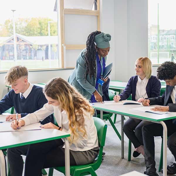 Teacher helps pupils after she has returned to teaching