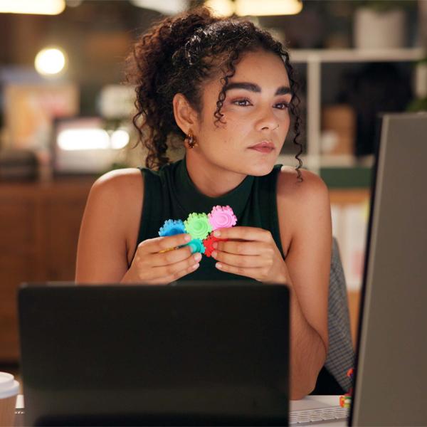 Business woman, laptop and thinking with pop toy, creative agency and ideas for night brainstorming. Girl, brand consultant and multi screen computer with project, proposal and office fidget spinner.