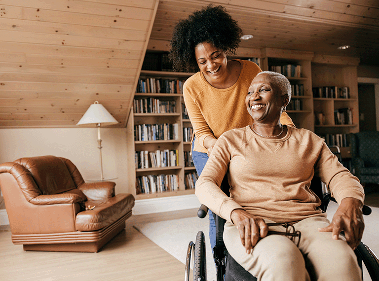 Carer supporting a woman at home in a wheelchair